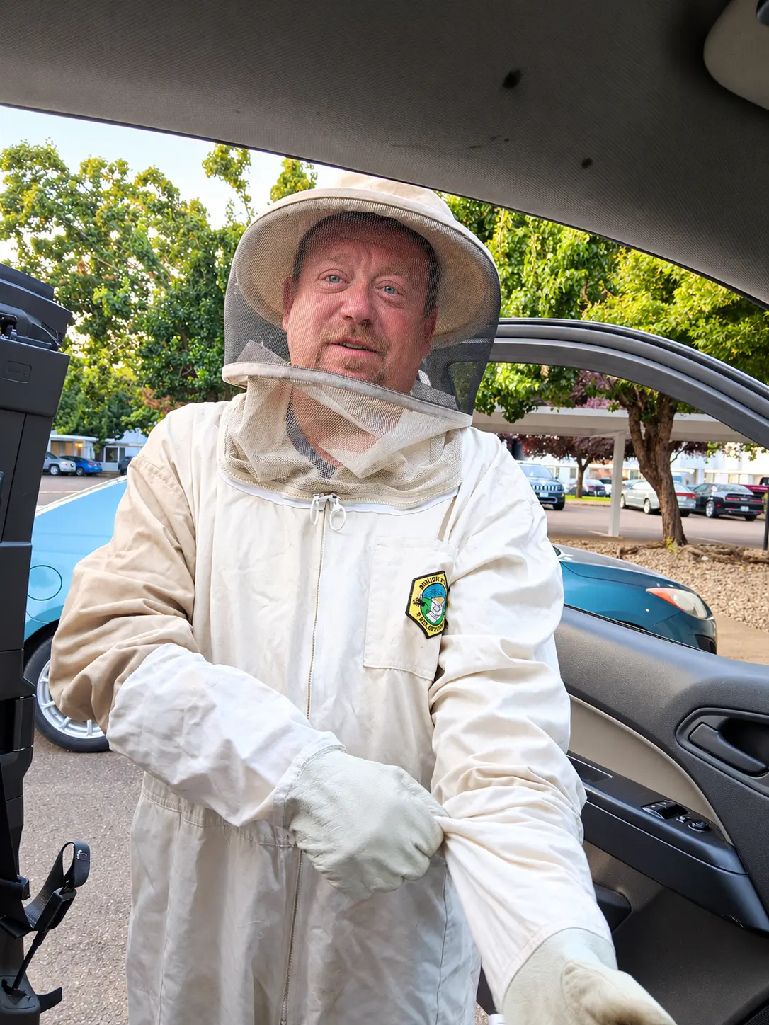 A Cherry City Pest Control technician in a protective bee suit and veil